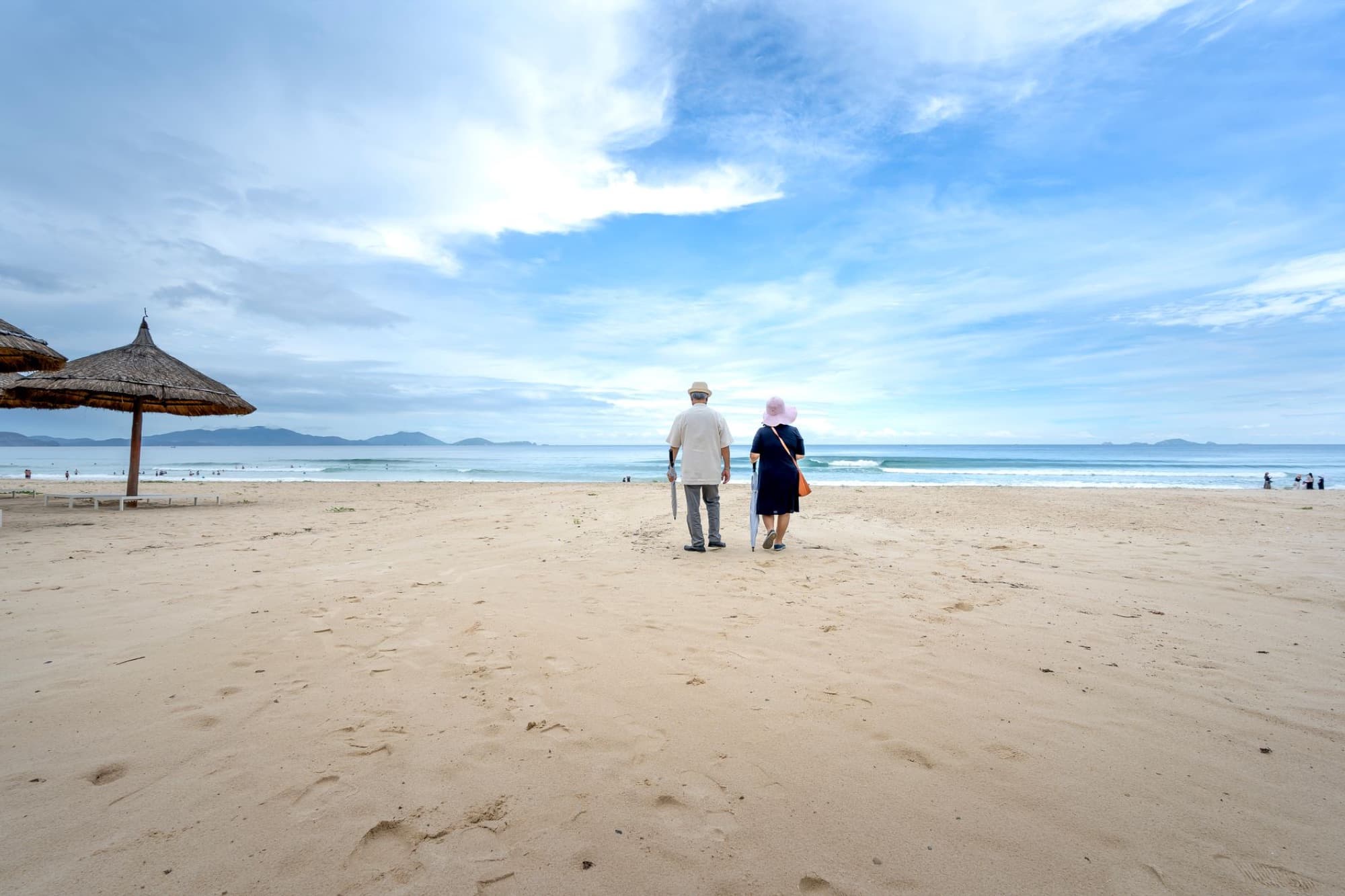 An older couple walking along the shoreline