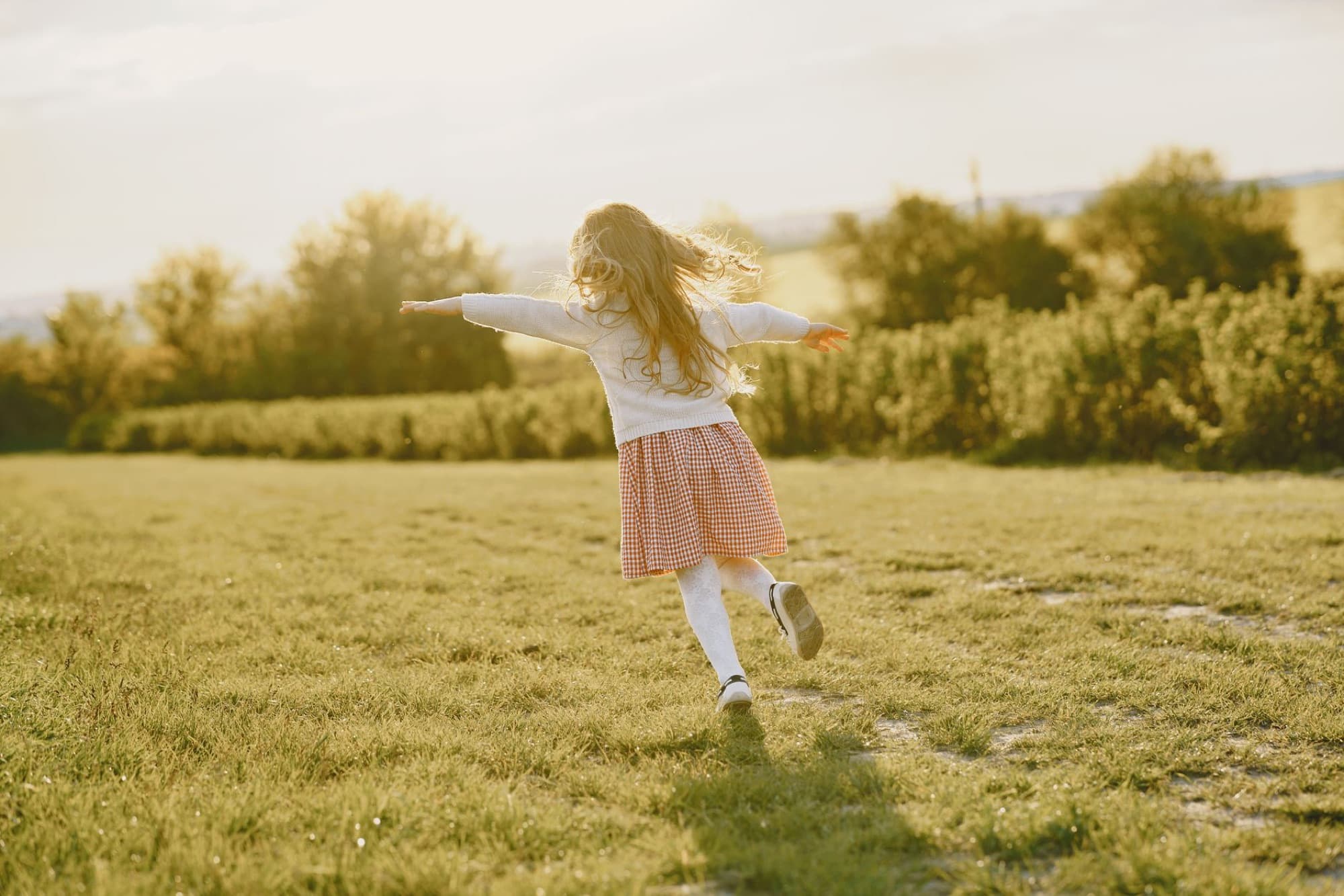 A child running through a backyard in the late afternoon