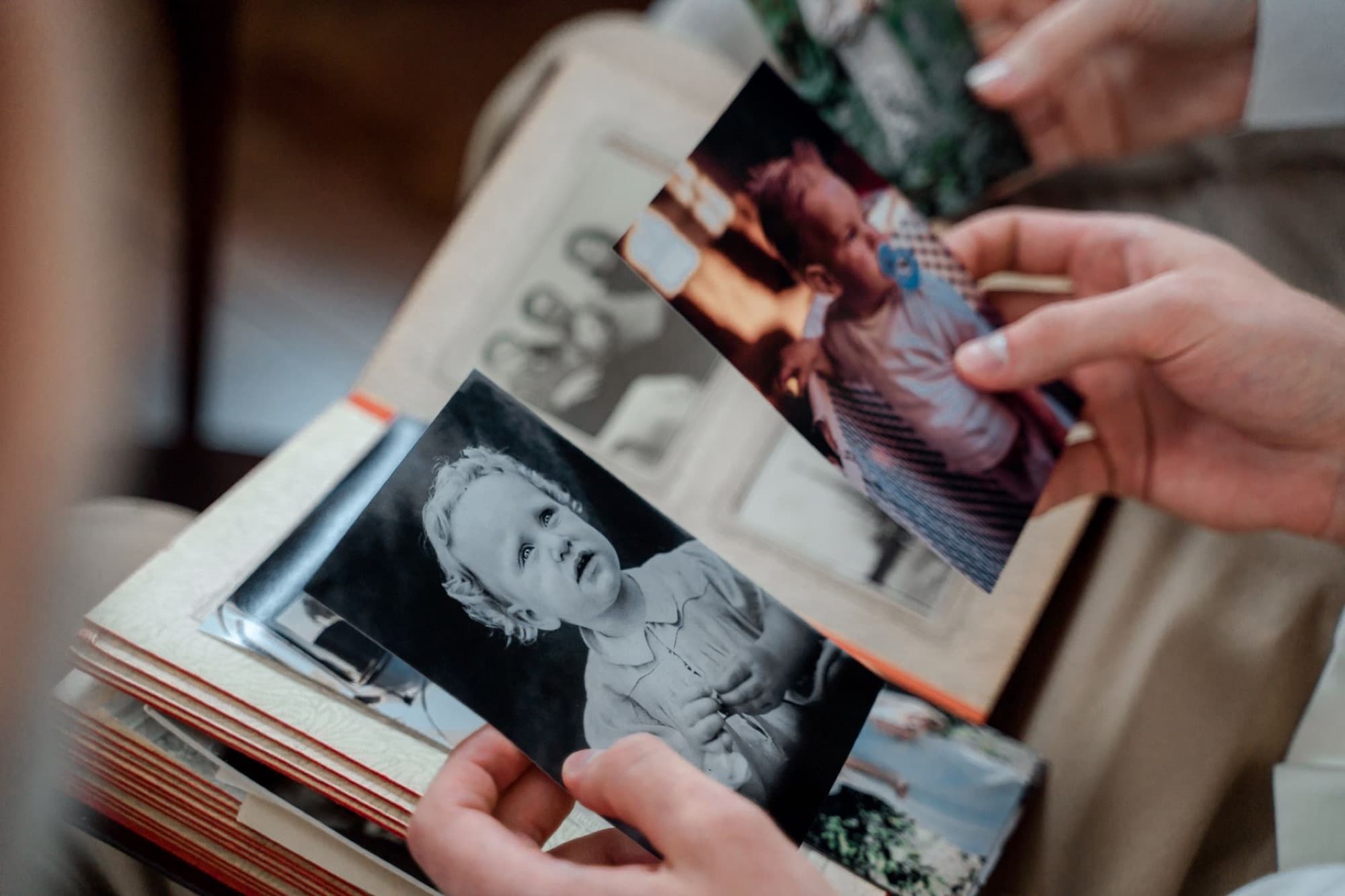 Hands turning the pages of an old family photo album
