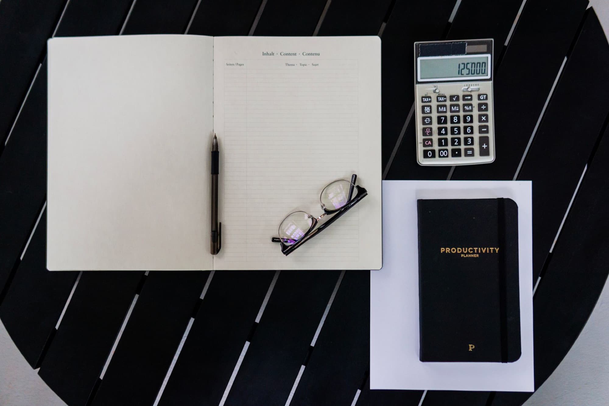 A notebook, pen, and printed figures on a desk