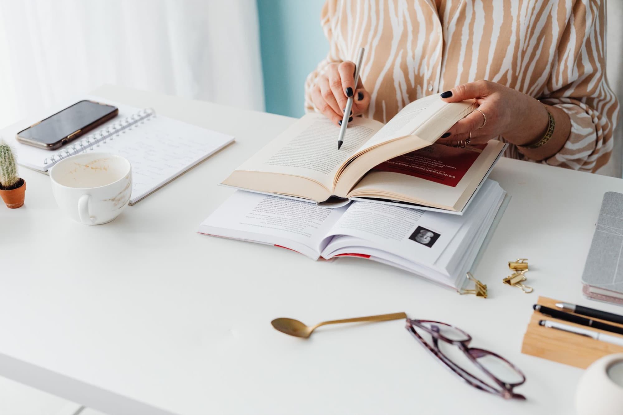 An open book and reading glasses under a lamp